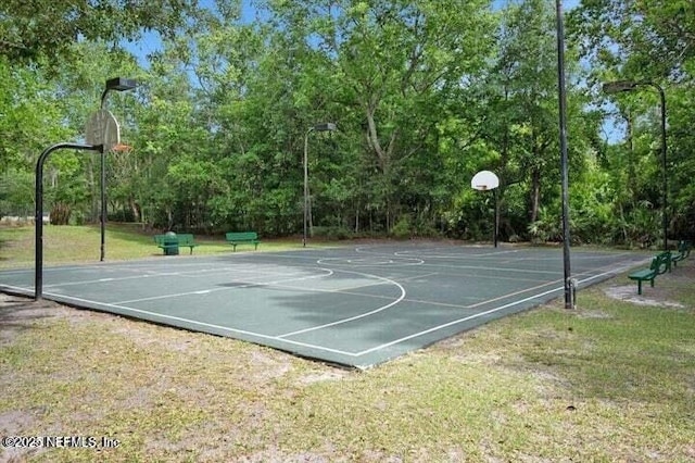 view of sport court with a lawn