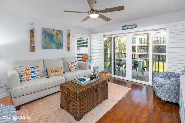 living room with dark wood-type flooring and ceiling fan