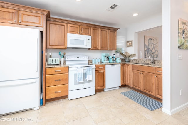 kitchen featuring sink, light stone countertops, white appliances, and light tile patterned flooring