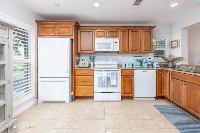 kitchen with white appliances, light tile patterned flooring, sink, and light stone countertops