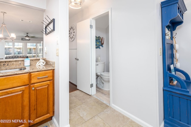 bathroom featuring tile patterned floors, ceiling fan with notable chandelier, toilet, and vanity