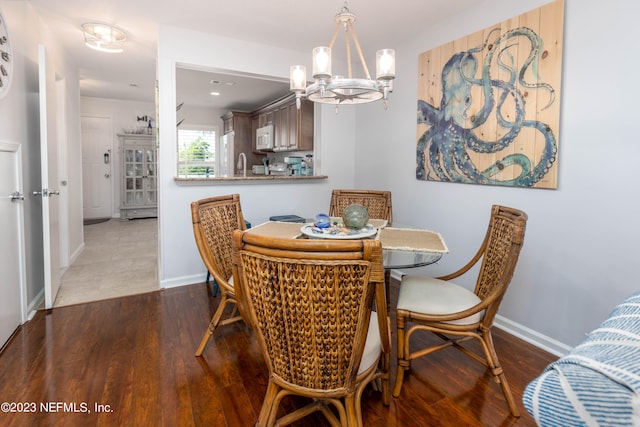 dining room featuring dark hardwood / wood-style floors, sink, and a notable chandelier