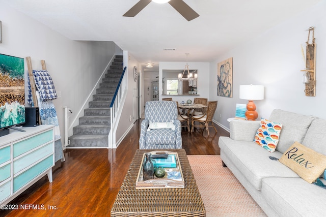 living room with dark wood-type flooring and ceiling fan with notable chandelier