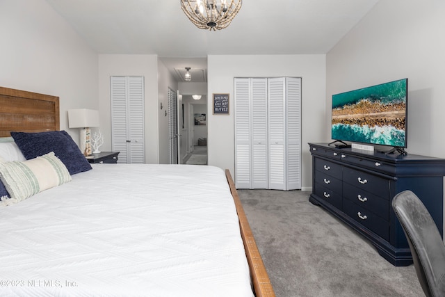 bedroom with two closets, light colored carpet, and an inviting chandelier