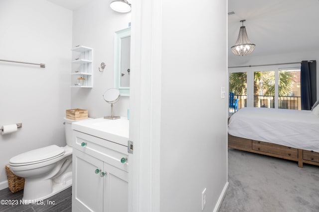 bathroom featuring toilet, an inviting chandelier, and vanity