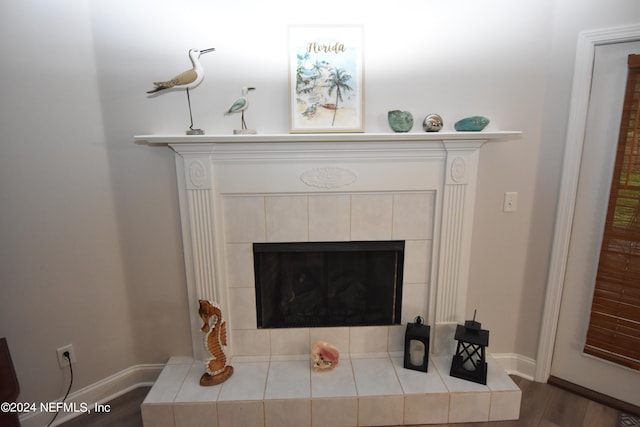 interior details featuring hardwood / wood-style floors and a tiled fireplace