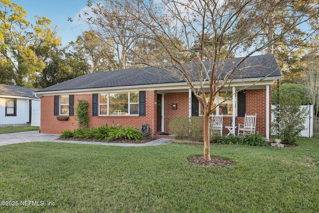 view of front of house featuring covered porch and a front lawn