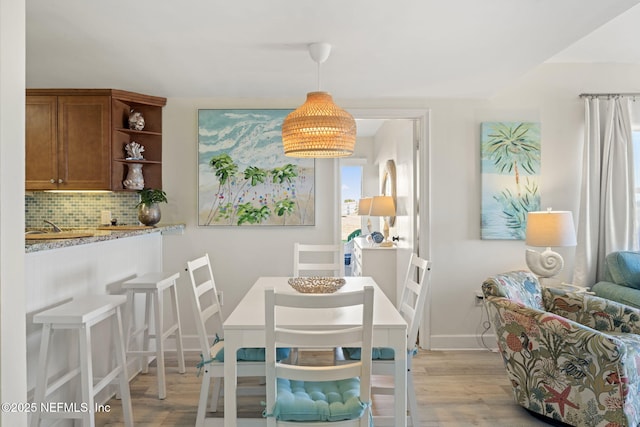 dining area featuring light wood-type flooring and sink