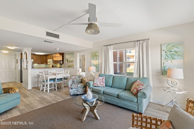 living room featuring ceiling fan and light hardwood / wood-style flooring