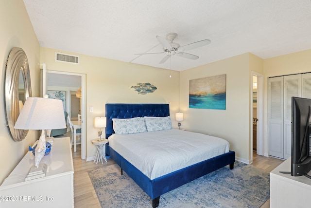 bedroom featuring a textured ceiling, a closet, ceiling fan, and light hardwood / wood-style floors