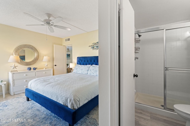 bedroom featuring ceiling fan, a textured ceiling, and light wood-type flooring