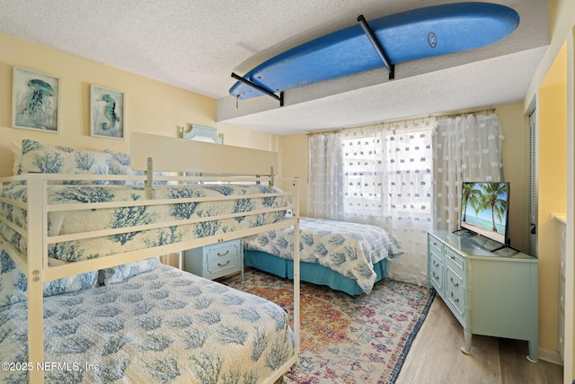 bedroom featuring a textured ceiling, light hardwood / wood-style floors, and a closet