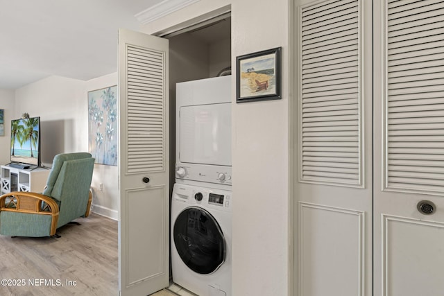 laundry area featuring light hardwood / wood-style floors and stacked washer / dryer