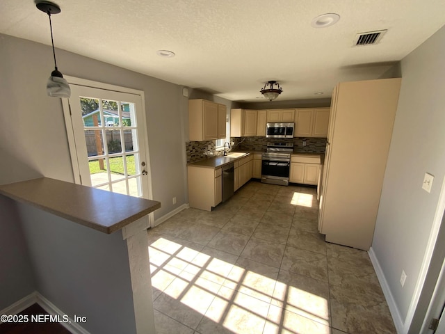 kitchen with baseboards, appliances with stainless steel finishes, visible vents, and decorative backsplash