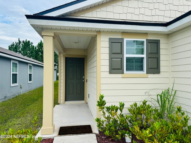 view of exterior entry featuring a yard