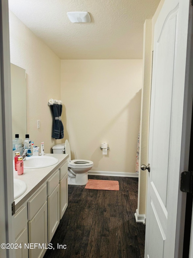 bathroom featuring a textured ceiling, vanity, toilet, and hardwood / wood-style floors