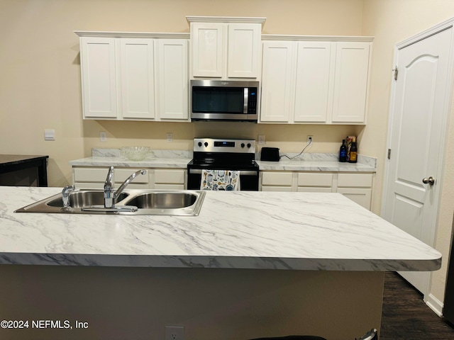 kitchen featuring appliances with stainless steel finishes, dark hardwood / wood-style flooring, sink, and white cabinets