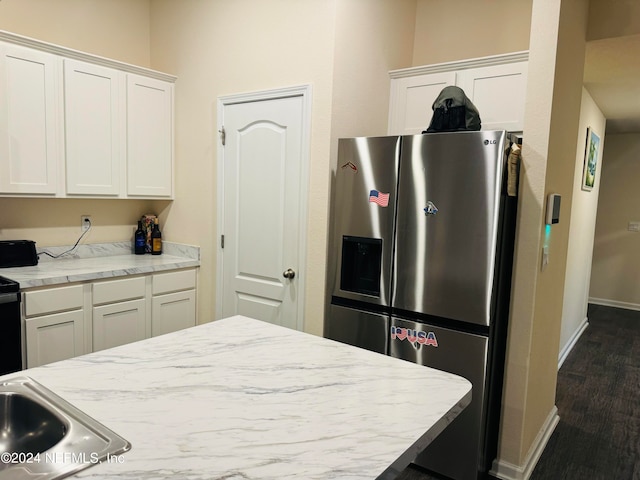 kitchen featuring stainless steel refrigerator with ice dispenser, sink, and white cabinets