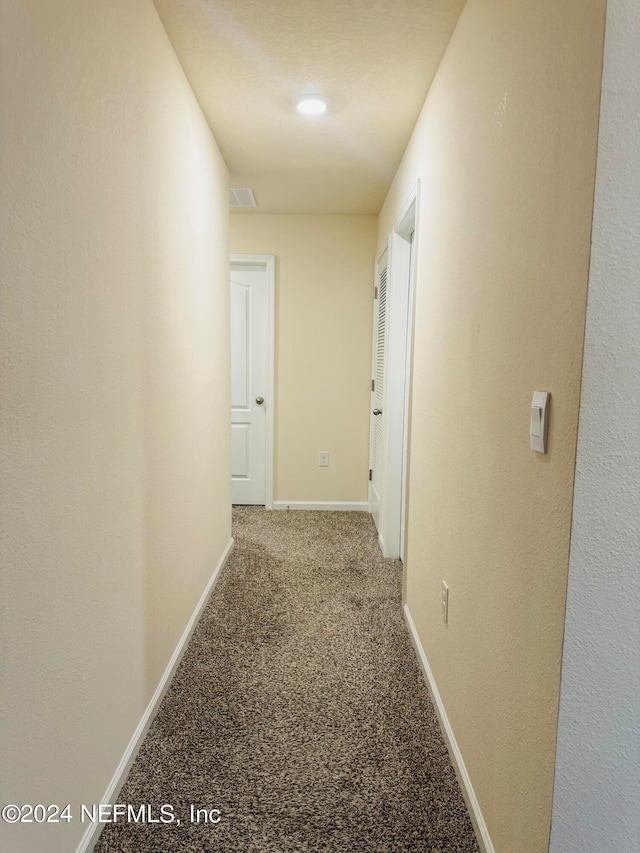 hall featuring carpet flooring