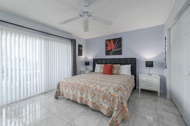 tiled bedroom featuring a textured ceiling, ceiling fan, and a closet