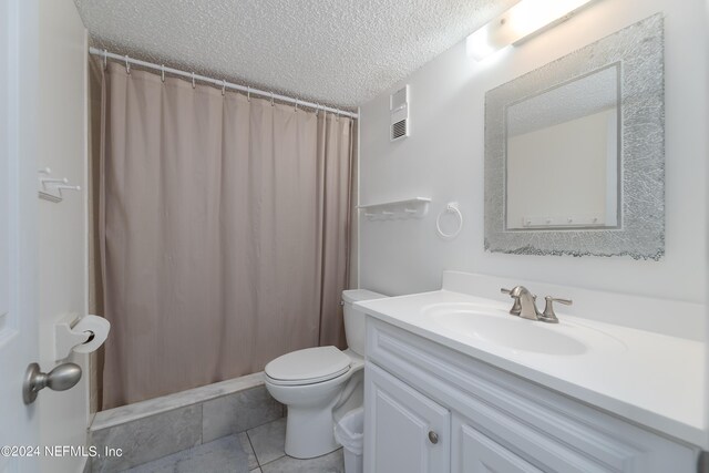 bathroom with toilet, tile patterned floors, vanity, a textured ceiling, and a shower with curtain