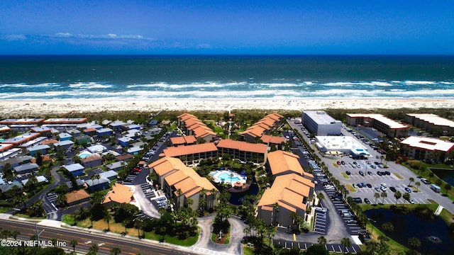 birds eye view of property featuring a beach view and a water view