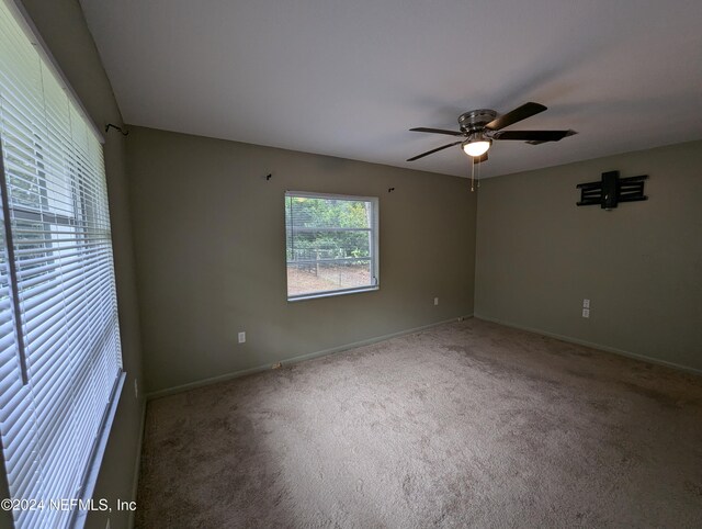 empty room featuring ceiling fan and carpet floors