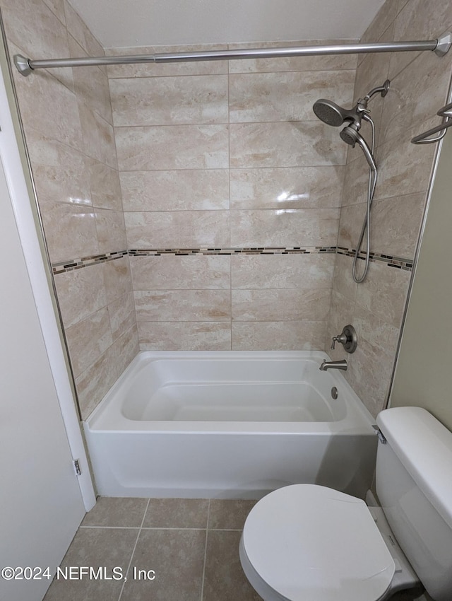 bathroom with tiled shower / bath, toilet, and tile patterned floors