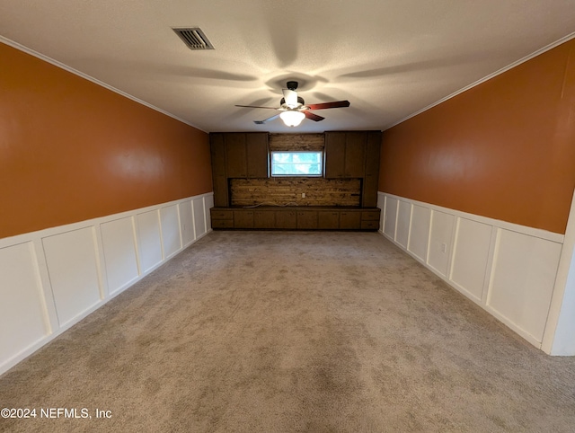 carpeted empty room with crown molding and ceiling fan