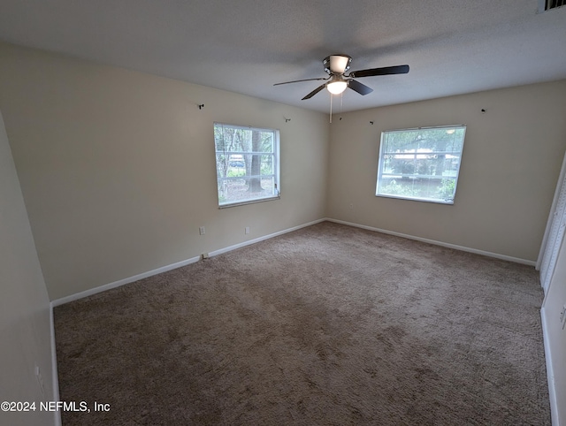 empty room with ceiling fan, carpet floors, and a healthy amount of sunlight