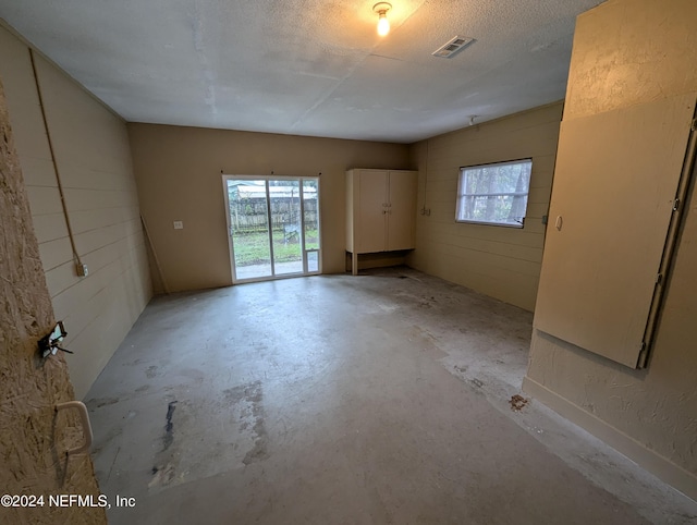 spare room featuring a textured ceiling and plenty of natural light