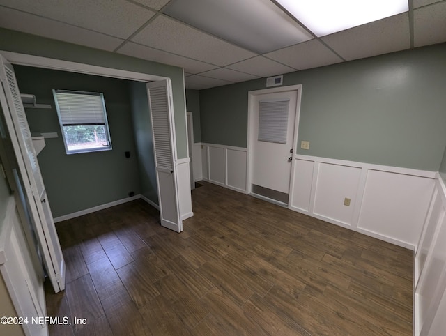 interior space featuring a drop ceiling and dark wood-type flooring