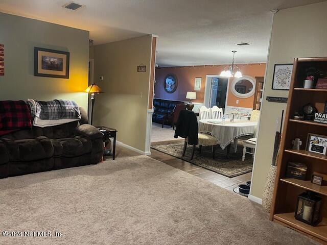 living room featuring light colored carpet and an inviting chandelier