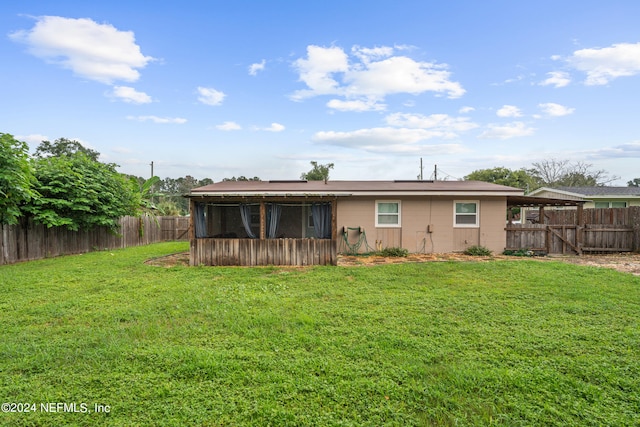 back of house with a yard and a sunroom