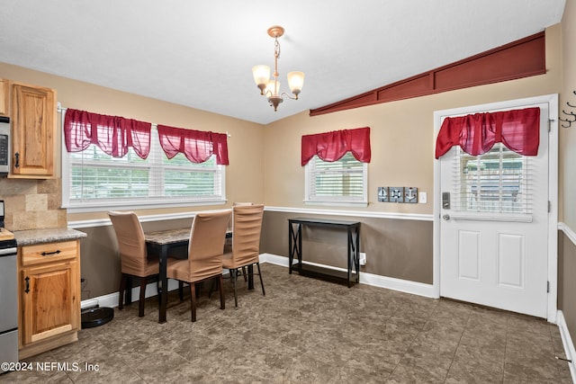 dining space featuring lofted ceiling and a notable chandelier