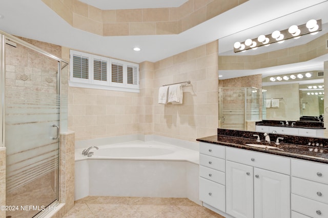 bathroom featuring vanity, shower with separate bathtub, tile walls, and tile patterned flooring