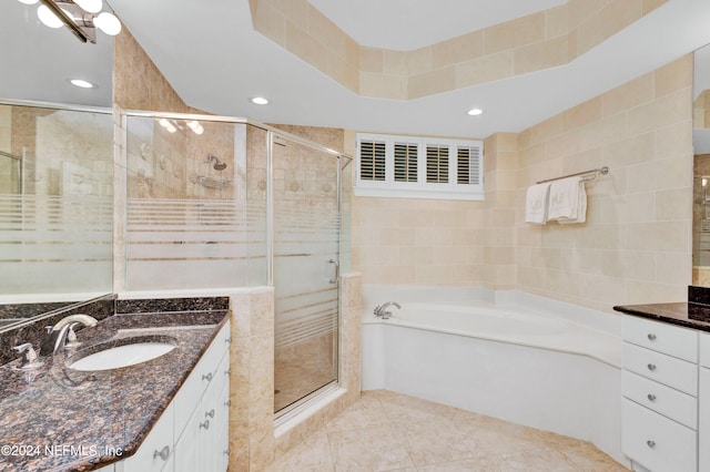 bathroom featuring tile walls, vanity, plus walk in shower, and tile patterned floors