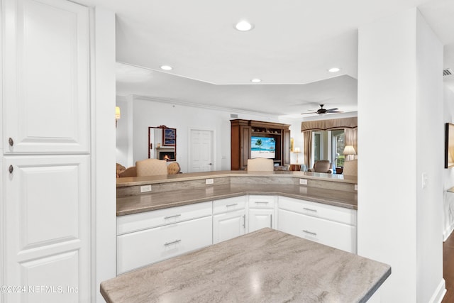 kitchen featuring kitchen peninsula, white cabinetry, and ceiling fan