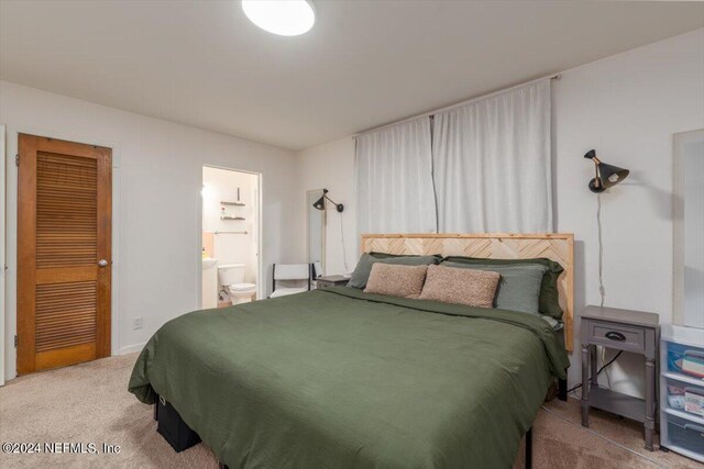 carpeted bedroom featuring ensuite bath