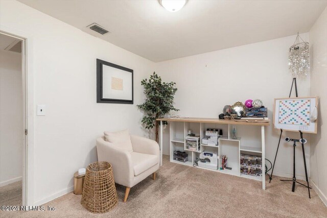 sitting room featuring light colored carpet