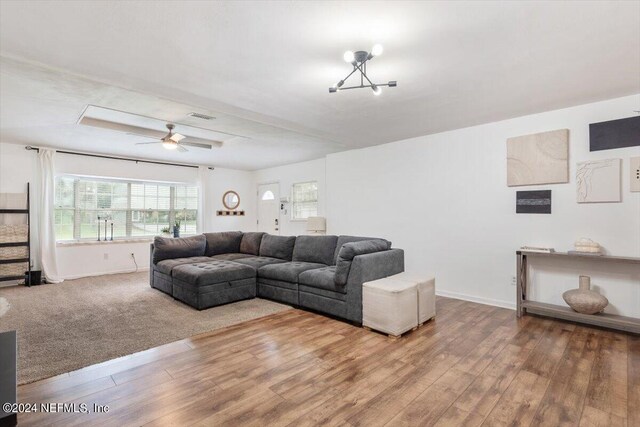 living room featuring ceiling fan with notable chandelier and wood-type flooring