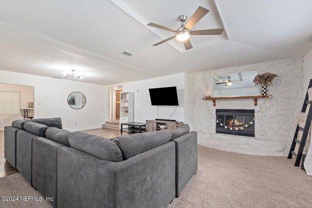 living room featuring ceiling fan, light colored carpet, and a fireplace