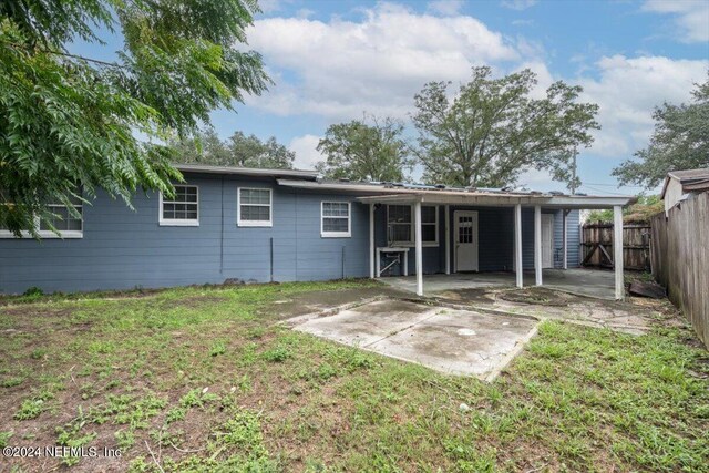 back of property featuring a lawn and a patio