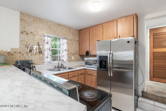 kitchen featuring stainless steel refrigerator with ice dispenser, sink, and decorative backsplash