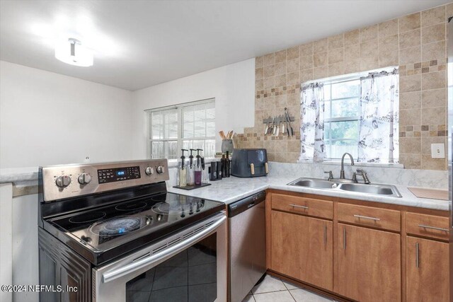 kitchen featuring stainless steel appliances, sink, and light tile patterned floors