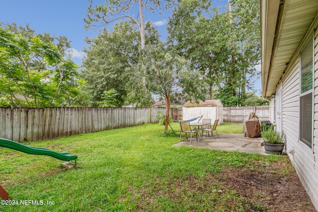 view of yard featuring a storage shed and a patio