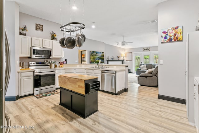 kitchen featuring ceiling fan, kitchen peninsula, light hardwood / wood-style flooring, white cabinetry, and stainless steel appliances