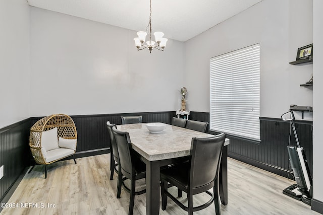 dining area with a notable chandelier and light hardwood / wood-style flooring