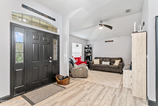 foyer entrance with light wood-type flooring, a textured ceiling, and ceiling fan