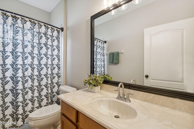 bathroom featuring walk in shower, vanity, and toilet